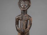 a wooden statue of a man with a hat on his head