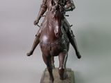 a bronze statue of a man riding a horse