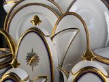 a lot of white and gold plates and cups