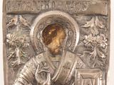 an image of a silver metal plaque with a picture of a man holding a cross