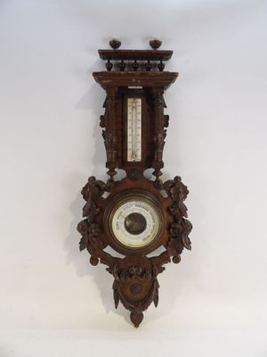 une horloge accrochée au mur, sur laquelle se trouve un baromètre