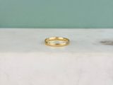 une photo d'une bague en or posée sur une dalle de marbre