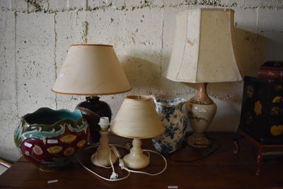 two lamps on a table next to a vase and a lamp shade