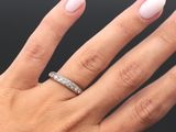 la main d'une femme, avec une manucure blanche et une bague en diamant
