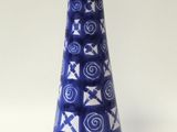 un vase bleu et blanc posé sur une surface blanche