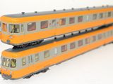 two toy trains sitting side by side on a white surface