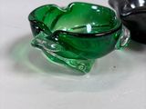 pair of green glass bowls sitting on top of a white table