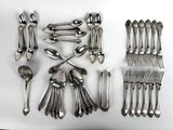 beaucoup de cuillères en argent et de cuillères à soupe sur une table