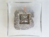 a picture of a silver ornament in a glass box