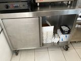 une cuisine équipée d'un plan de travail en inox et d'un micro-ondes