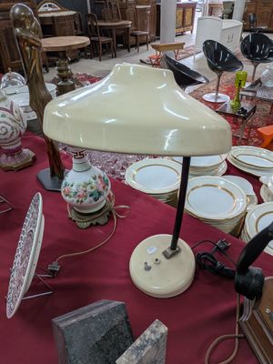 une table sur laquelle se trouvent une lampe et de nombreuses assiettes