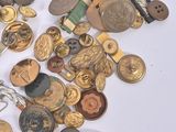 a pile of gold and silver buttons on a white surface