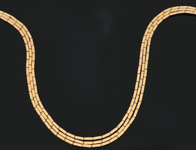 a gold necklace on a black background with a black background