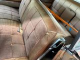 a dirty seat in the back of an old car