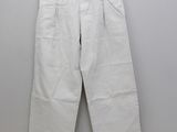 a white pants hanging on a hanger against a wall