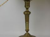 an antique brass table lamp with a white shade on a white background
