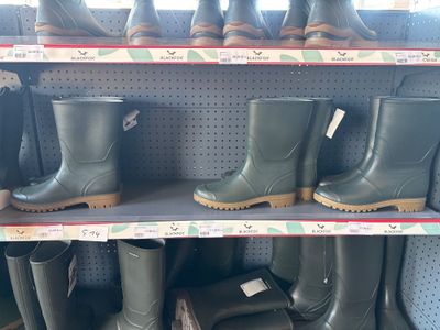 many pairs of rain boots on the shelves in the store