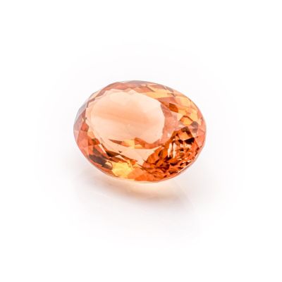 a close up of an orange diamond on a white surface