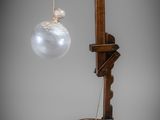 une lampe à l'ancienne dont le bras est orné d'une boule en verre
