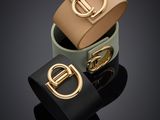 trois bracelets en cuir de couleurs différentes, dotés d'une boucle dorée