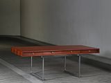 a wooden bench sitting in the middle of an empty room