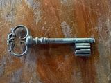 a metal key that is laying on a wooden table