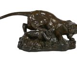 statue en bronze représentant un chat et un chien sur un rocher