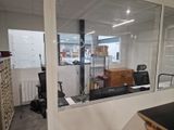 une pièce avec un bureau, une chaise et une grande fenêtre