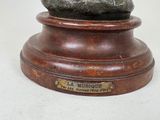 a statue of a man sitting on top of a wooden base