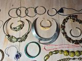 many different types of bracelets and rings laid out on a table