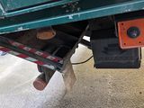 a green truck with a red and black box underneath it