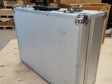 a silver suitcase sitting on a table in a warehouse