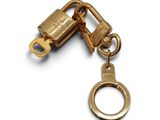 porte-clés plaqué or avec un cadenas sur fond blanc