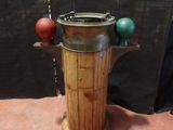 a wooden barrel with a metal lid on a stand