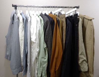 a lot of shirts hanging on a rack in a room
