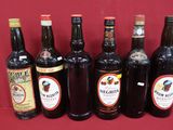 six bouteilles de vin sont alignées sur une surface rouge