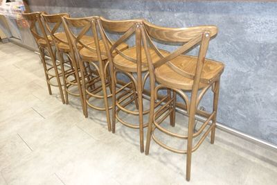 quatre tabourets de bar en bois sont alignés contre un mur