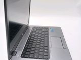 a silver laptop with a black keyboard on a white surface