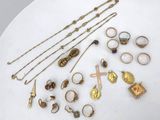 a white plate topped with lots of gold jewelry on top of a table
