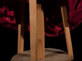a red cloth draped over a wooden stand on a black background