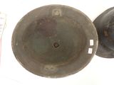 two metal bowls sitting next to each other on a table