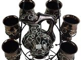a black and white vase and cups on a stand