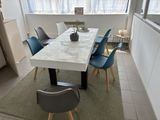 une table blanche avec des chaises bleues et une plante posée dessus