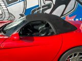 a red sports car parked in front of a graffiti covered wall