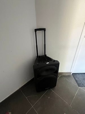 a black piece of luggage sitting against a white wall