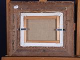 an old picture frame is sitting on top of a wooden easel