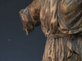 bronze statue of a woman holding a cigarette in her right hand