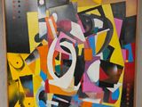 tableau représentant des formes et des couleurs abstraites, encadré et accroché au mur