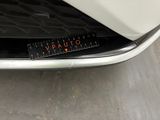 a close up of a white car with a sticker on it ' s bumper