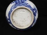 a blue and white vase sitting on a black surface
